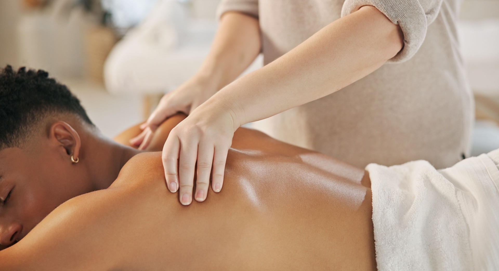 Therapist, man and hands massage back for health, relax and spine wellness at luxury resort. Masseuse, peace and calm person at spa for body care, stress relief and client with skincare treatment