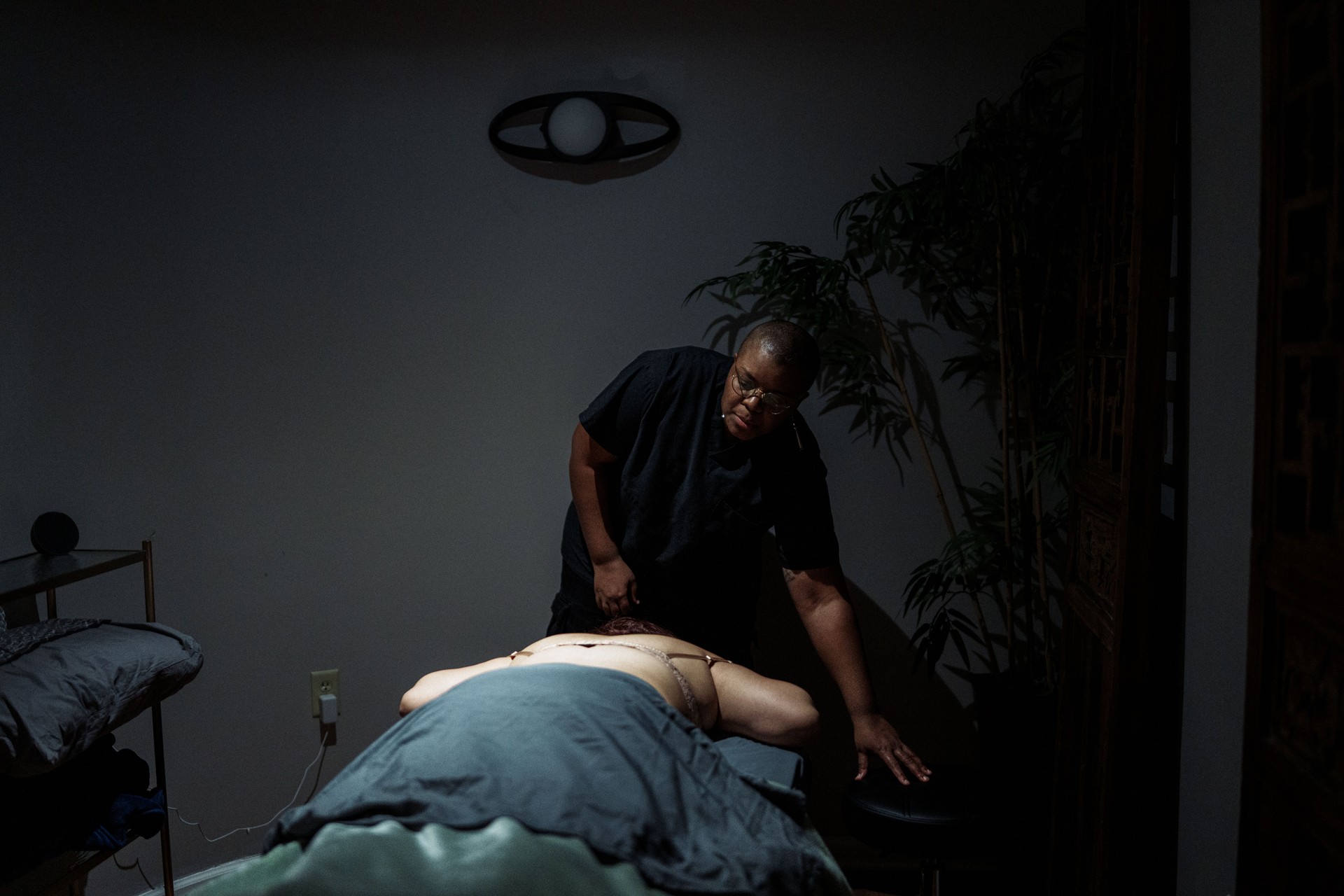 Massage therapist preparing to massage female client's back